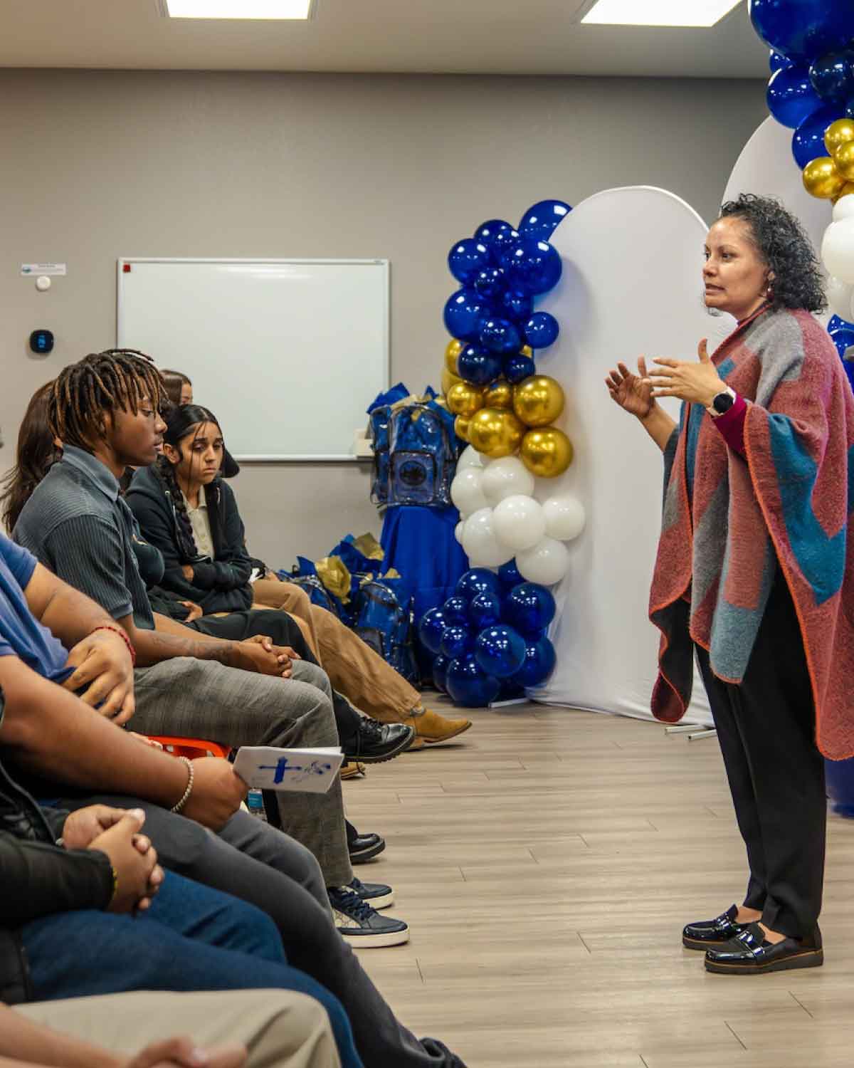 A community mentor speaking to an attentive group of youth at the Fresno BHC Youth Internships Program event, emphasizing leadership development, civic engagement, and inspiring others to apply for future internships.