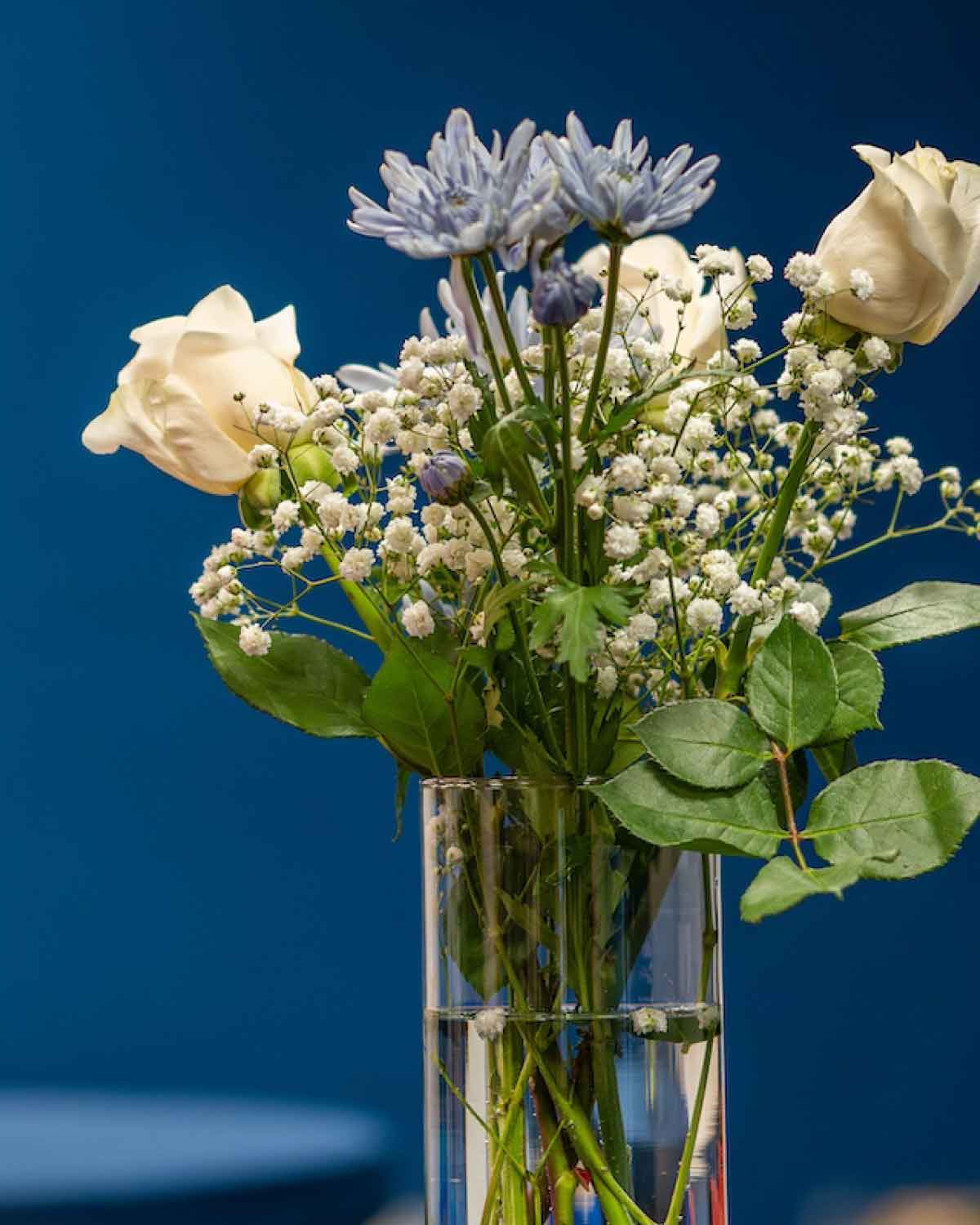 A vase of white and blue flowers adorning the Fresno BHC Youth Internships Program space, representing a welcoming, celebratory atmosphere for youth leaders and supporters.