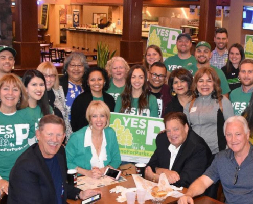 Supporters of Measure P in Fresno celebrate at a community event, promoting increased investment in parks and green spaces for a healthier city.