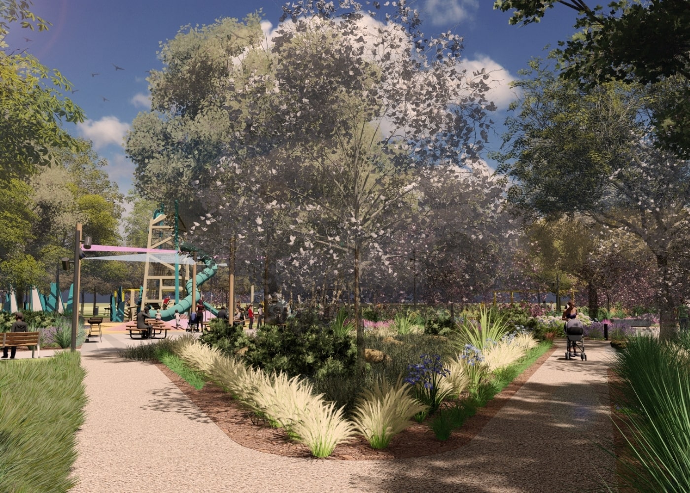 A peaceful park scene with split walkways surrounded by lush landscaping, ornamental grasses, and flowering plants, leading toward a shaded playground area with a tall slide and canopy-covered seating.