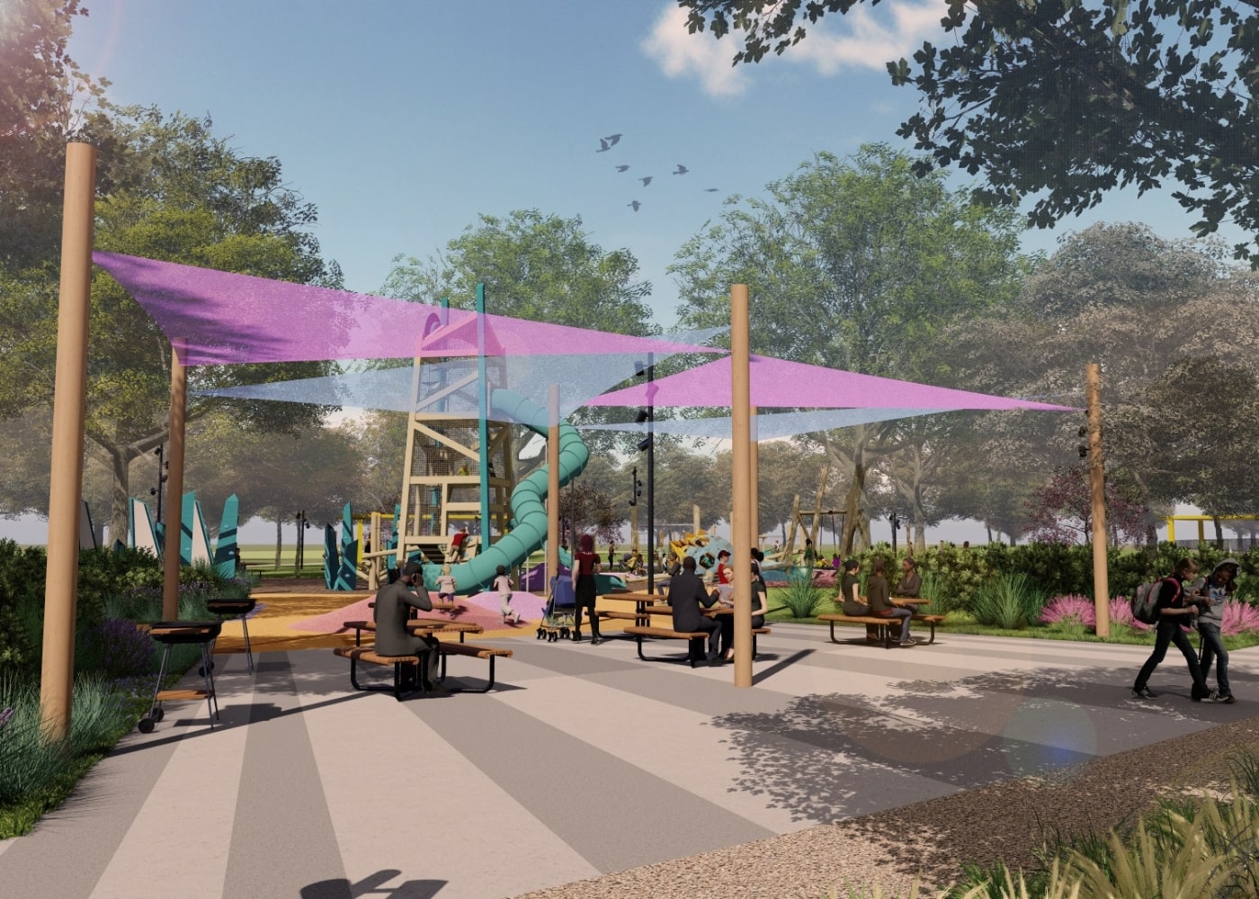 Families and children gather under purple shade sails in a picnic area near an adventurous playground with a tall turquoise slide tower.
