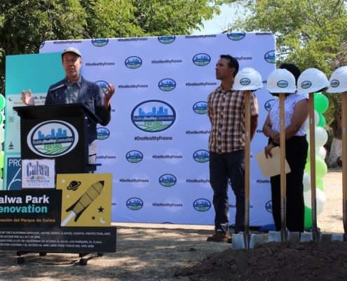 Speaker addresses crowd at Calwa Park’s groundbreaking, highlighting the importance of investment in parks and community wellness.
