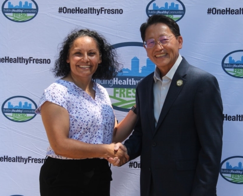 Leaders of the Calwa Park project shake hands, symbolizing collaboration and shared investment in the community.