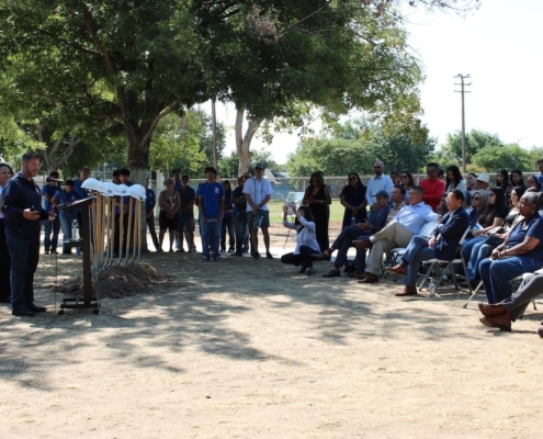 Audience seated under the trees at Calwa Park listens to speakers during the groundbreaking event hosted by Fresno Building Healthy Communities.