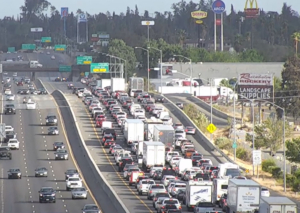 Traffic congestion with diesel trucks and cars on California freeway highlighting pollution impacts in South Fresno