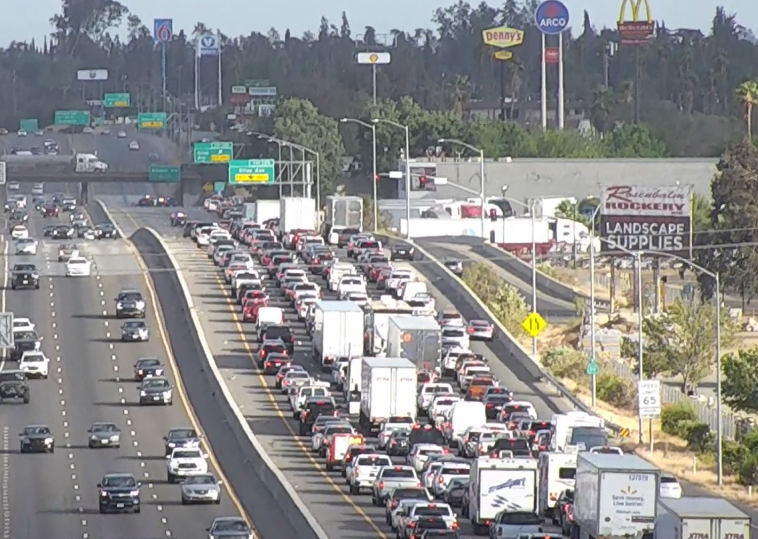 Traffic congestion with diesel trucks and cars on California freeway highlighting pollution impacts in South Fresno