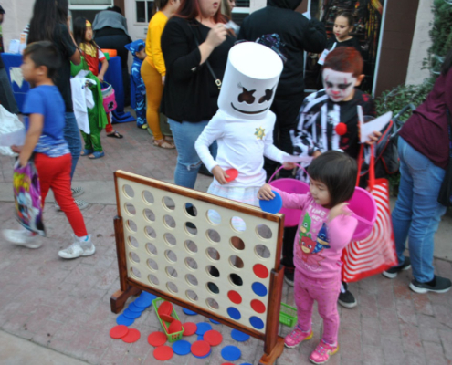Children in Halloween costumes playing a giant Connect Four game at Fresno BHC’s Well-O-Ween event