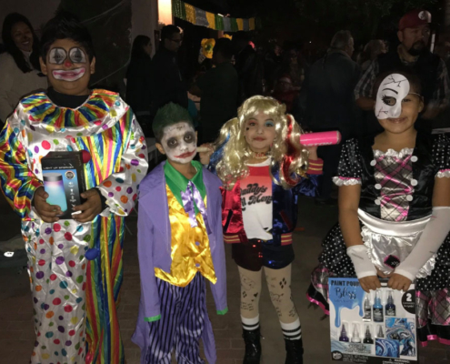 Kids dressed as colorful Halloween characters smiling together at Fresno BHC’s Well-O-Ween celebration