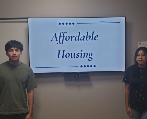 Youth interns standing beside their Affordable Housing capstone project presentation at Fresno BHC