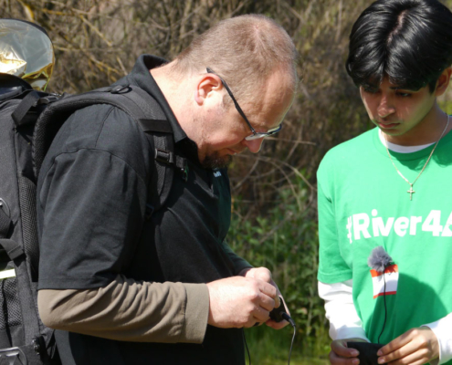 Fresno BHC youth volunteer working with a cameraman to prepare recording equipment for a River4All interview about the CEMEX Quarry project
