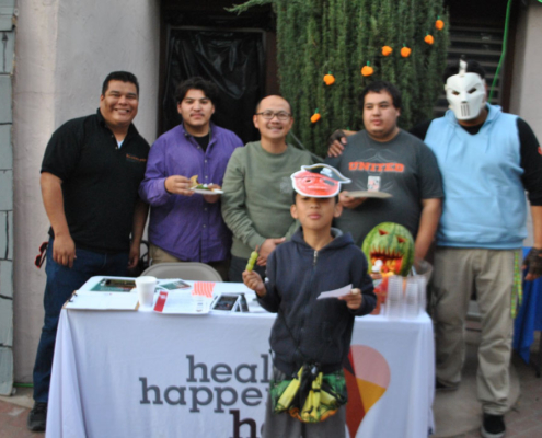 Group of volunteers and community members at the Health Happens Here table during Well-O-Ween