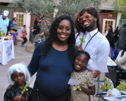 Family dressed in Halloween costumes smiling together at Fresno BHC’s annual Well-O-Ween event