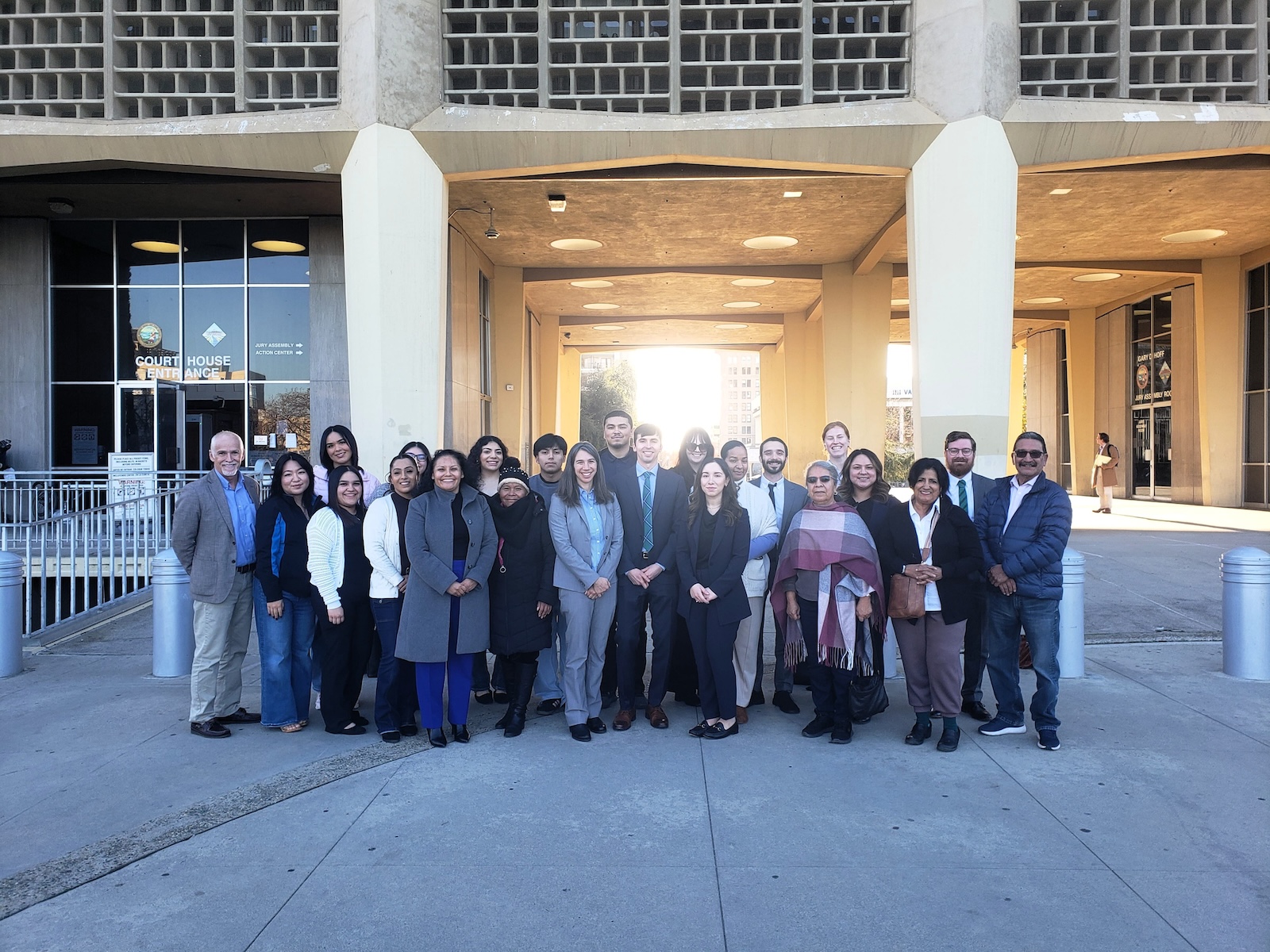 Did Caltrans Shortchange South Fresno? Judge Weighs Highway 99 Expansion Lawsuit A wide group portrait of about twenty people of diverse ages and backgrounds standing in front of a modern "Court House Entrance." They are dressed in a mix of professional and business-casual attire. The courthouse features a unique concrete honeycomb-style facade.