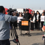 Media record a press conference where community advocates gather at a trucking site in Fresno to demand accountability for California DMV commercial license revocations.