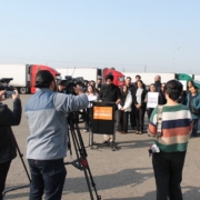 Wide view of a press conference with advocates, workers, and media highlighting the economic impact of California DMV paperwork errors on working families.